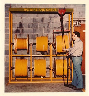 a man adjusting six reels of TPC cable in the Mentor warehouse and distribution center